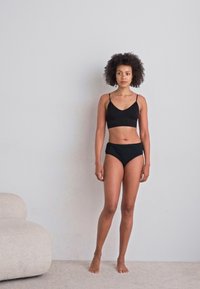 Zwart bralette en set met hoge tailleslips, met een gladde textuur, minimalistisch ontwerp en verstelbare schouderbanden.