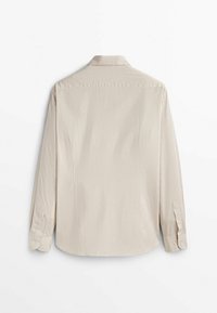 Chemise beige clair à manches longues avec un motif à carreaux, col boutonné et détails aux poignets. Tissu doux et coupe ajustée.