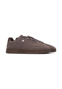 Sneaker marroni con una texture liscia, design con lacci, suola in gomma, dettagli di cucitura discreti e un piccolo logo accentato di lato.