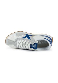 Gray sneaker with blue accents, mesh and suede materials, rounded toe, white laces, and a gum rubber sole. Features logo on tongue.