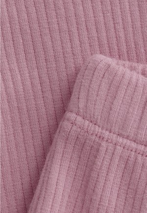 Nahaufnahme von weichem, geripptem Strickstoff in hellem Mauve mit sichtbaren Nahtdetails an der gefalteten Kante.