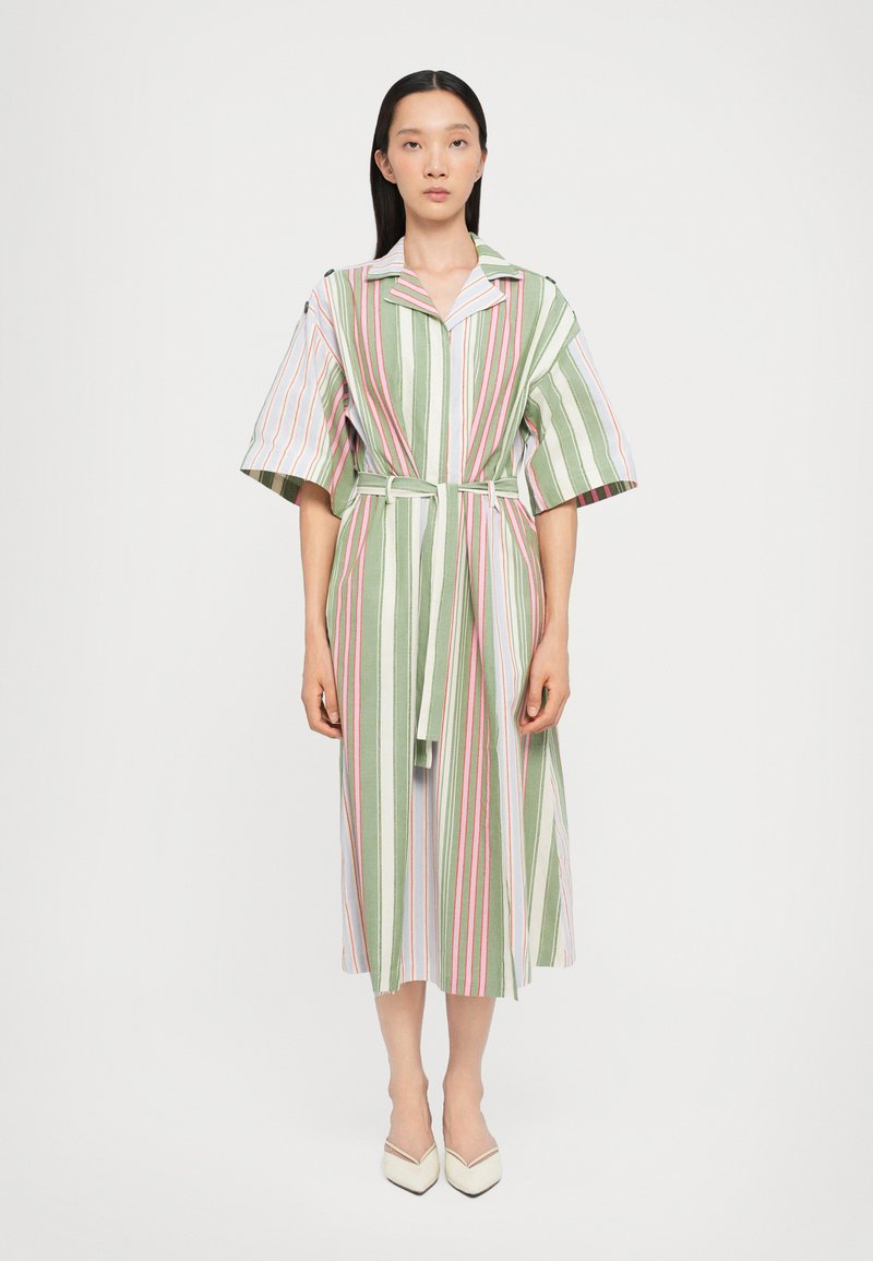 Robe rayée en vert, blanc, rose et bleu ; présente des manches courtes, un col, une ceinture et une jupe mi-longue avec des fentes sur les côtés.