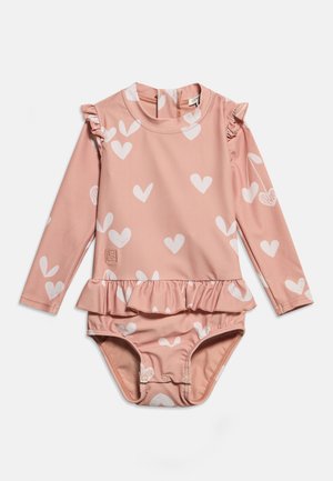 Różowy jednoczęściowy kostium kąpielowy dla dziecka z długim rękawem, białymi wzorami serc, falbankami na ramionach i w talii oraz zatrzaskami na dole.