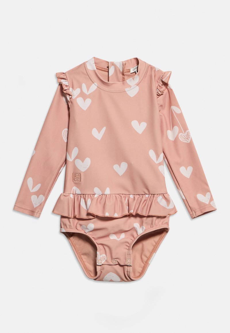 Ροζ παιδικό μαγιό με μακριά μανίκια, λευκά σχέδια καρδιών, βολάν στους ώμους και τη μέση, και κουμπώματα στο κάτω μέρος.