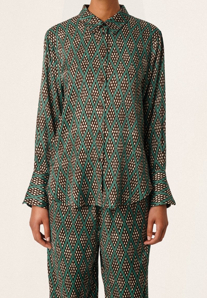 Set di pigiama a motivi verdi e marroni con un design a diamante, composto da una camicia con colletto e maniche lunghe, e pantaloni larghi.