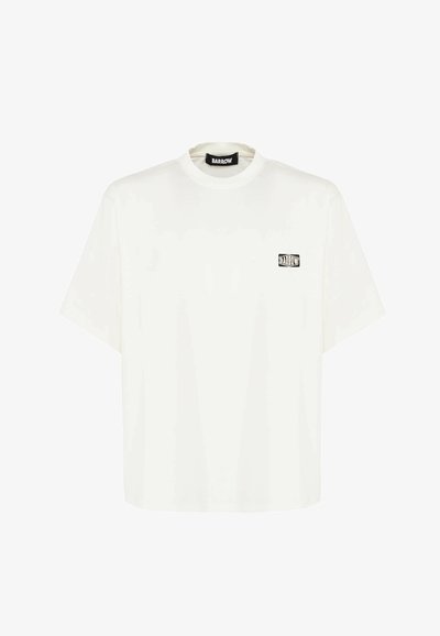 Camiseta blanca de manga corta fabricada en algodón, con un corte cuadrado y un pequeño logo gráfico negro en el lado izquierdo del pecho.