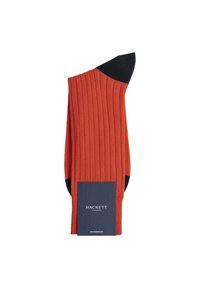 Calza rossa a coste con punta e tallone neri, caratterizzata da una parte superiore piegata e un'etichetta che riporta la scritta "HACKETT LONDON" in bianco su uno sfondo navy.