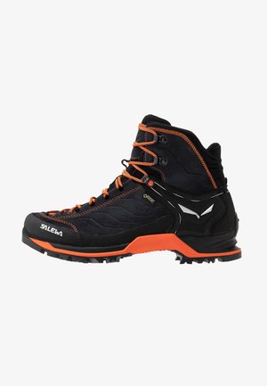 Scarponcino da trekking nero con accenti arancioni, realizzato in suede e materiali sintetici, dotato di una caviglia alta, suola robusta e motivo testurizzato.