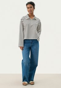 Ribade, pika varrukaga pullover, millega on kaelus ja lukuga, valmistatud kergest kangast. Kombineeritud lahtiste siniste denimitehnika pükstega.
