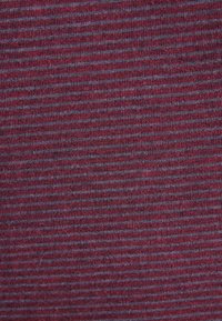 Primo piano di un tessuto a maglia fitta con strisce orizzontali sottili alternate in rosso scuro e grigio tenue.
