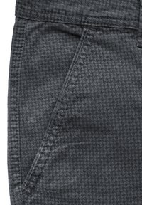 Šedá látka s vzorem, která se vyznačuje designem houndstooth, s detailním pohledem na kapsu a kontrastním prošíváním.