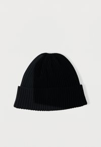 Beanie nero a coste con risvolto. Texture morbida e forma affusolata, adatta a diverse misure di testa.