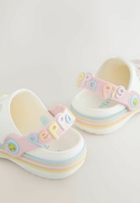 Hvide plastiksandaler med en pink rem med farverige "Peppa Pig"-bogstaver, blomsterdetaljer og lagdelte pastelfarvede striber på sålen.