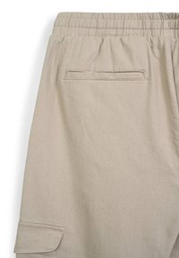 Beige Cargo-Hosen mit elastischem Bund, ausgestattet mit einer aufgesetzten Tasche auf der Rückseite und einem glatten, strukturierten Stoff.