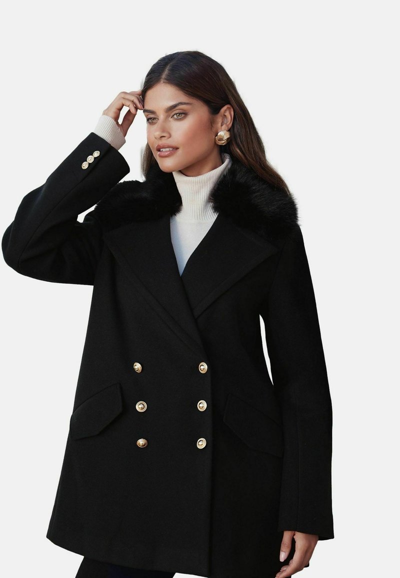 Čierny dvojradový kabát so zlatými gombíkmi, umelá kožušina na golieri, prispôsobený strih a dlhé rukávy. Obsahuje dve predné vrecká.