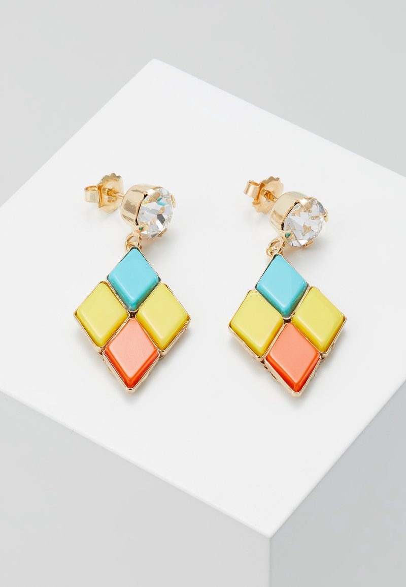 Boucles d'oreilles en or avec des pierres rondes transparentes et des formes de diamant suspendues en émail bleu, jaune et orange sur une surface blanche.