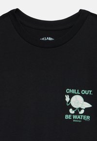 Czarna koszulka z krótkim rękawem z miętową grafiką przedstawiającą postać z kreskówki oraz napisem "CHILL OUT. BE WATER" na lewej piersi.