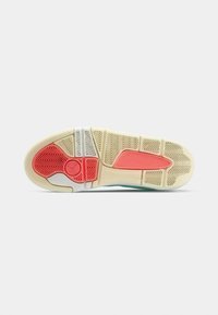 Podošva topánky s gumovitým povrchom; má biely základ, korálové a červené akcenty a geometrický dezén pre lepšiu priľnavosť.