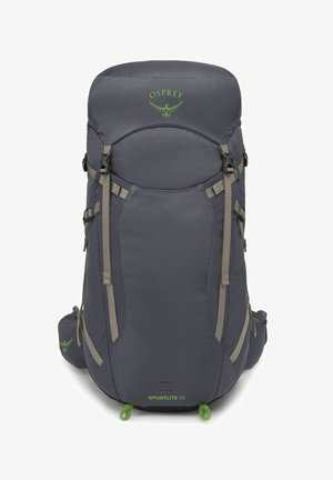 Sac à dos Gray Osprey Sportlite 30 avec des sangles kaki, un haut arrondi et des poches avant. Présente un logo et des accents verts, texture de tissu durable.