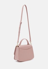 Sac à main structuré rose doux avec une poignée supérieure et une longue bandoulière ajustable, présenté sur un fond blanc.