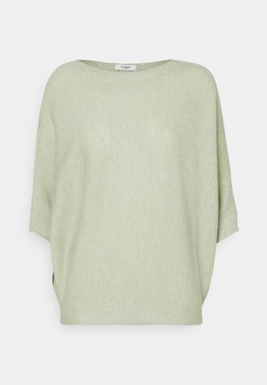 Pull ample en maille vert clair avec larges manches et encolure ronde, présenté sur un fond uni.