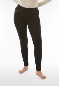Leggings neri con una superficie liscia, vita alta elastica e due tasche frontali con dettagli in metallo argentato.