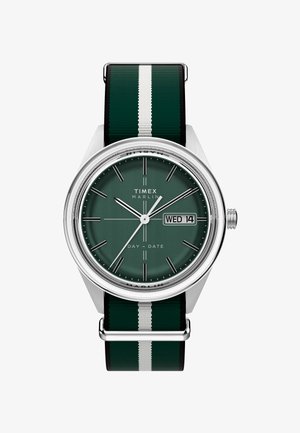 Zegarek Timex Marlin z zieloną tarczą, srebrnymi elementami i czarną/zieloną paskiem z tkaniny w paski. Posiada wyświetlacz dnia/datę oraz minimalistyczny design.