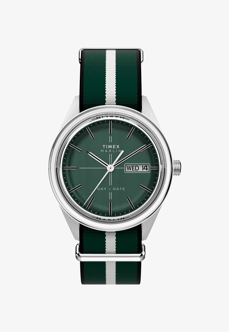 Timex Marlin sat s zelenim brojčanikom, srebrnim detaljima i crno-zelenom prugastom tekstilnom narukvicom. Ima prikaz dana/datuma i minimalistički dizajn.