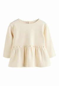 Ljusbeige långärmad topp med ribbad textur, som har en rynkad peplummidja, rund halsringning och en knappstängning på baksidan.