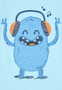 Mostro dei cartoni animati ricamato in blu con cuffie arancioni, sorride ampiamente, con le braccia sollevate, su uno sfondo di tessuto azzurro chiaro. Note musicali sopra.