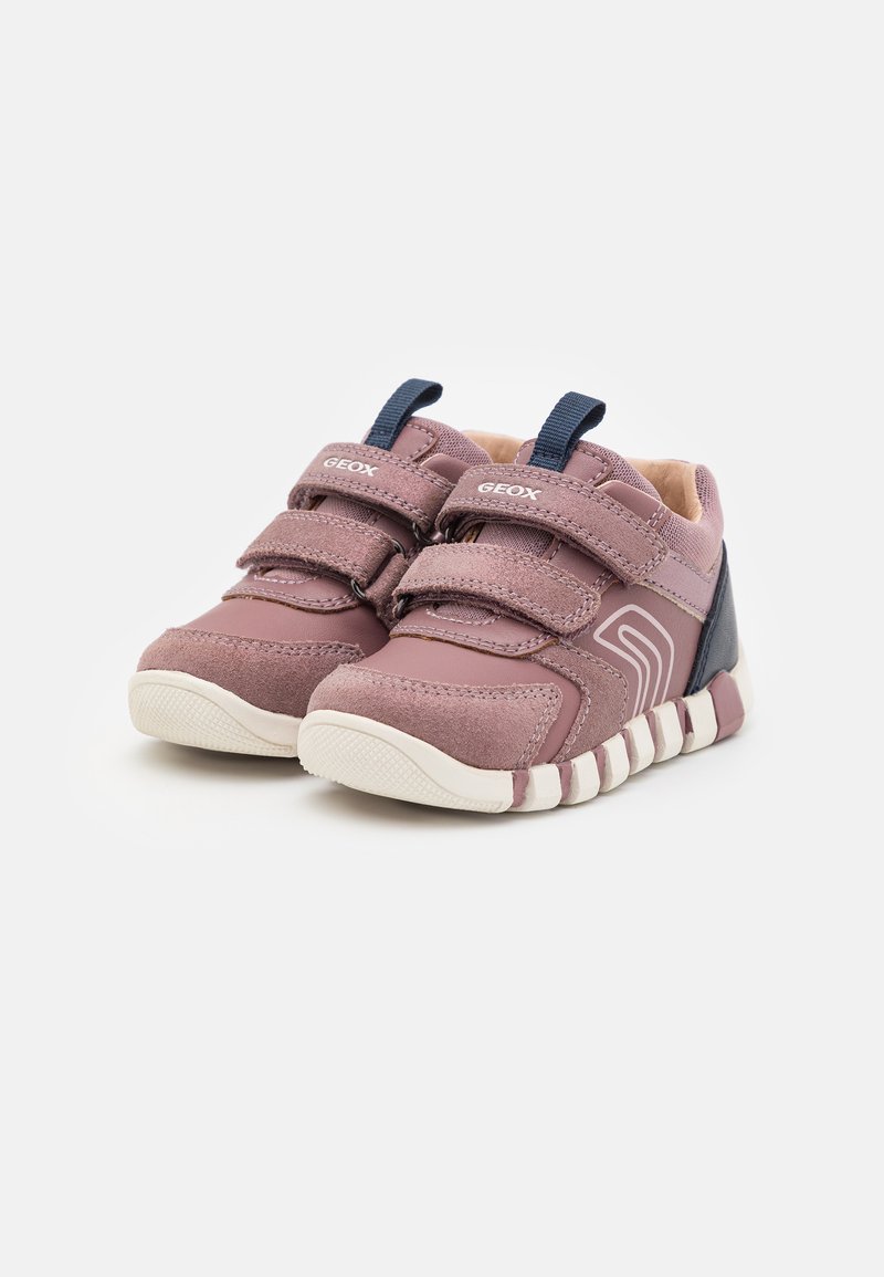 Sneakers per bambini viola e rosa con doppie cinghie in Velcro, suola in gomma, colletto imbottito e un design geometrico sul lato.