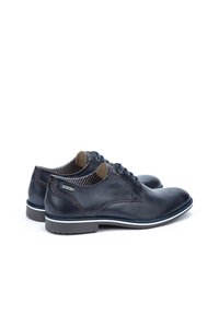 Navy blue leather shoes with round toe, smooth surface, contrasting white sole, and subtle brown stitching detail. Lined interior features stripes.