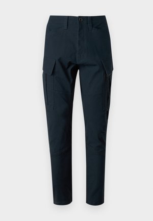 Navy blue cargo pants with a fitted shape, multiple side pockets, a zip detail on one leg, and stitched accents for durability.