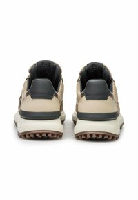 Beige suede and leather sneakers with a dark heel cap, textured rubber outsole, and an insole design featuring brand details.
