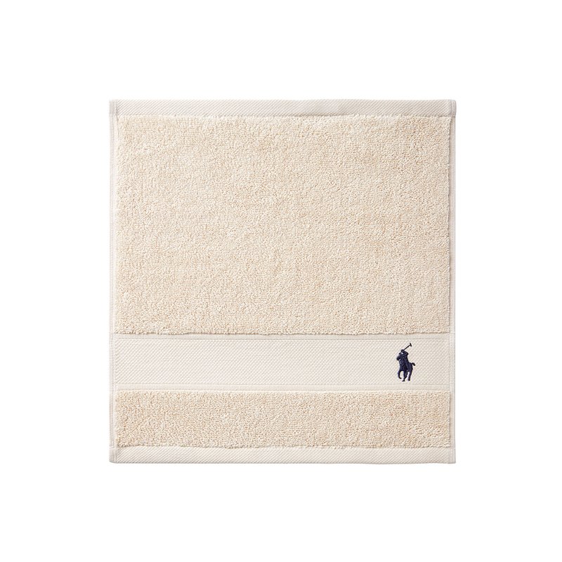 Πετσέτα από μπεζ πετσέτα βελουτέ με υφή στην επι φάνεια και ομαλή ρίγα. Κεντημένο σκούρο μπλε λογότυπο ιππέα με ρόπαλο στο κάτω μέρος.