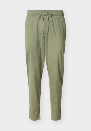 Hellolivgrüne, schmal geschnittene Jogginghose mit elastischem Bund, Kordelzugverschluss und Seitentaschen, flach auf einem weißen Hintergrund liegend.