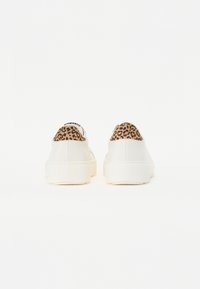 Sneaker bianchi in pelle con un accento in stampa leopardata marrone testurizzata sul tallone. Forma arrotondata e suole in gomma spesse.