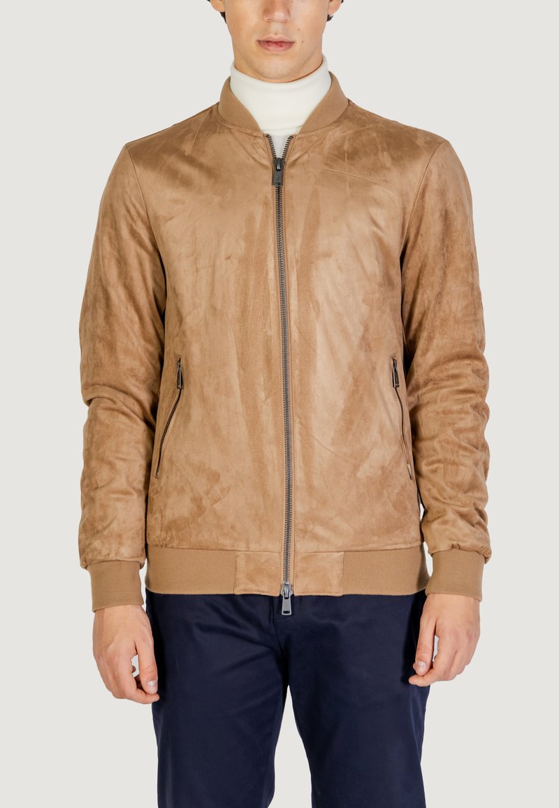 Chaqueta bomber de ante sintético color beige con cremallera frontal, puños y bajo de canalé; cuenta con bolsillos laterales y una textura suave.