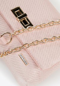 Sac à main tissé rose avec une finition texturée, doté d'une chaîne en or et d'un fermoir en or. Comprend une étiquette de marque visible : Wittchen.
