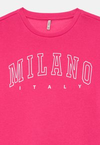 Ljust rosa sweatshirt med rund hals som har vit konturerad text "MILANO" i stora bokstäver och "ITALY" i mindre bokstäver under. 