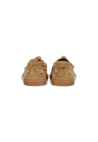 Zapatillas de ante marrón con un acabado texturizado, forma redondeada y suelas de goma. Presentan acentos decorativos y un diseño minimalista.