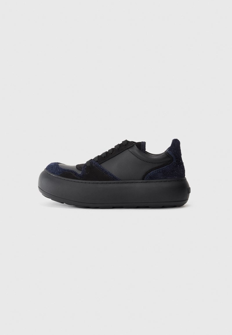 Black and navy sneaker featuring a combination of leather and textured fabric, round toe, thick rubber sole, and tonal lace-up design.