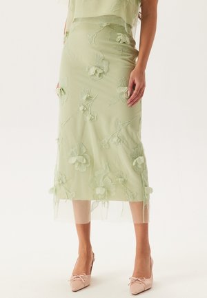 Mintgrüner Midirock mit floraler Bestickung. Transparenter Stoff mit geschichtetem Textur, zeichnet sich durch zarte Blumenmuster und ein sanft fließendes Design aus.