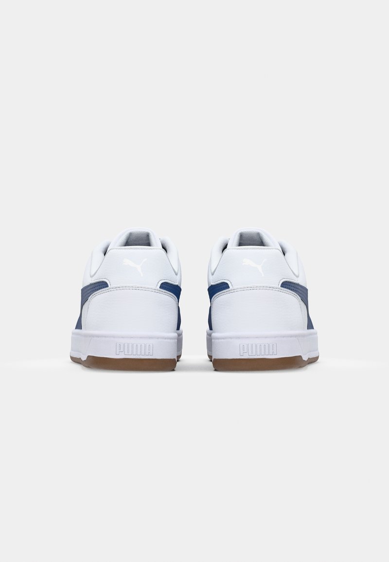 Baskets blanches avec des accents marine, en matériau synthétique texturé, semelle en caoutchouc et col rembourré avec le logo Puma sur le talon.