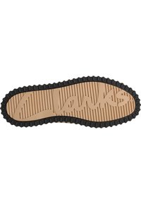 Semelle de chaussure en caoutchouc beige avec des bords noirs. Présente des nervures texturées et un logo "Clarks" gravé. Forme courbée avec des bords arrondis.