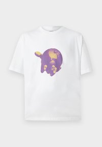 T-shirt en coton blanc avec un motif central violet et or représentant une main tenant un globe, avec des manches courtes et un col rond.