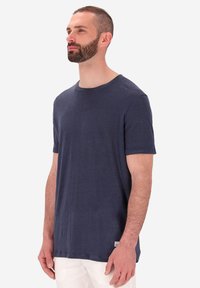T-shirt a maniche corte blu navy in un tessuto morbido e textured. Design a collo giro con taglio dritto e una piccola etichetta di marca sull'orlo.