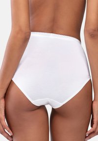 Korkeavyötäröiset valkoiset puuvillalaput, joissa on aallotettu vyötärö, sileä pinta ja täydellinen peittävyys. Ei näkyviä kuvioita tai koristeita.