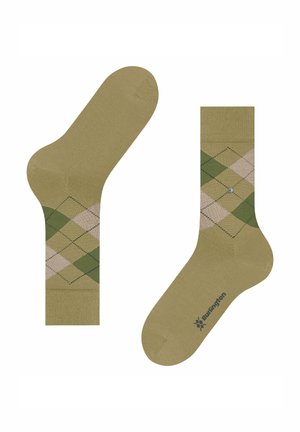 Chaussettes vertes à motif losanges argyle avec des losanges beige, arborant un logo gris et une texture en maille lisse. Longueur chevilles avec pointe et talon renforcés.
