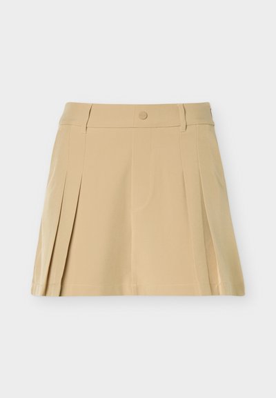 Beige plisseret mininederdel med bæltestropper, knaplukning og syninger på en ensfarvet baggrund.